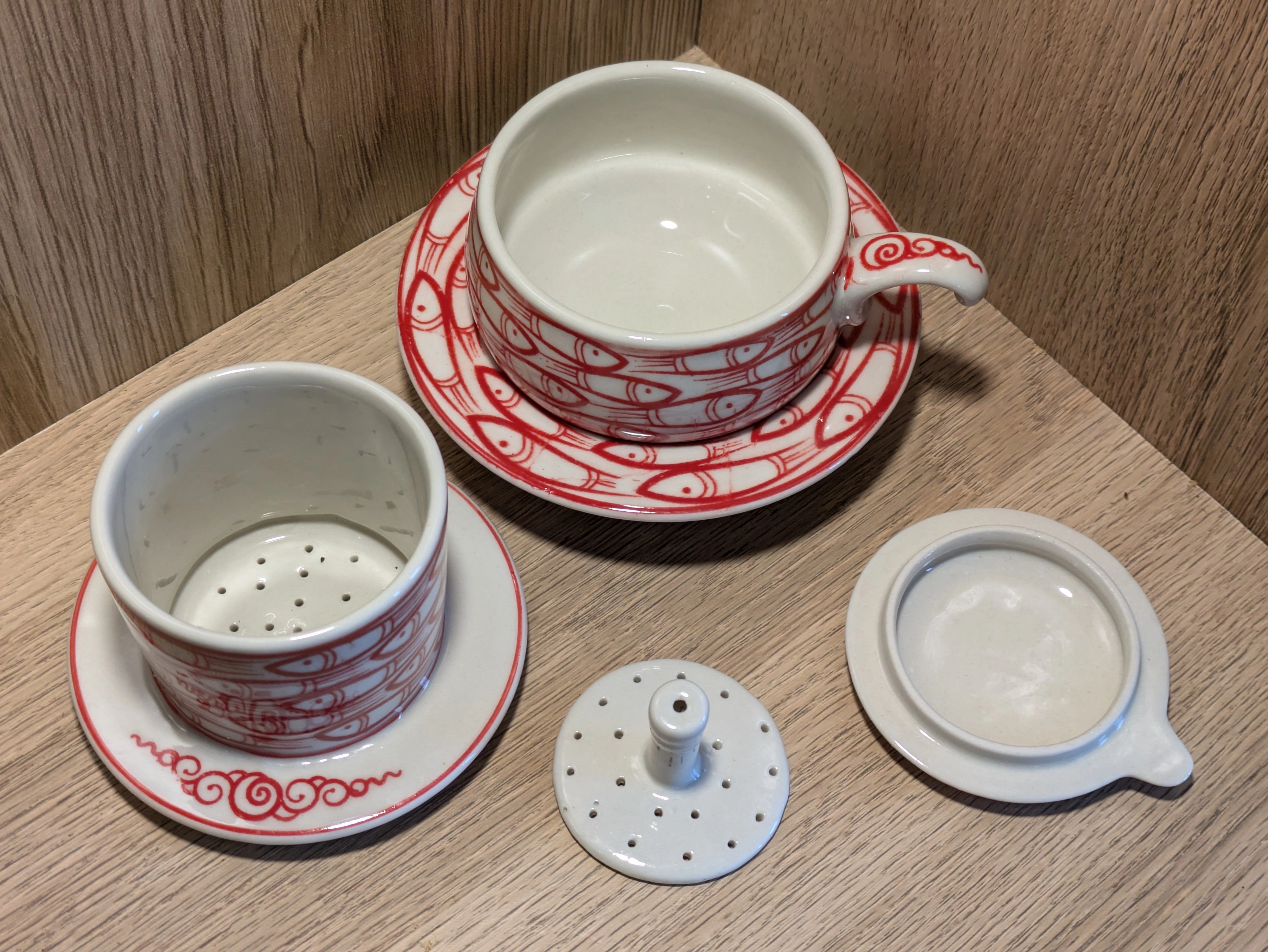 En haut, la tasse. De gauche à droite : le filtre, le tasseur, le couvercle.