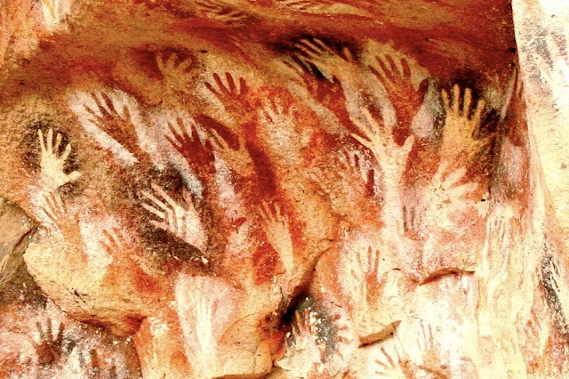 Peinture rupestre de mains sur la paroi d'une grotte