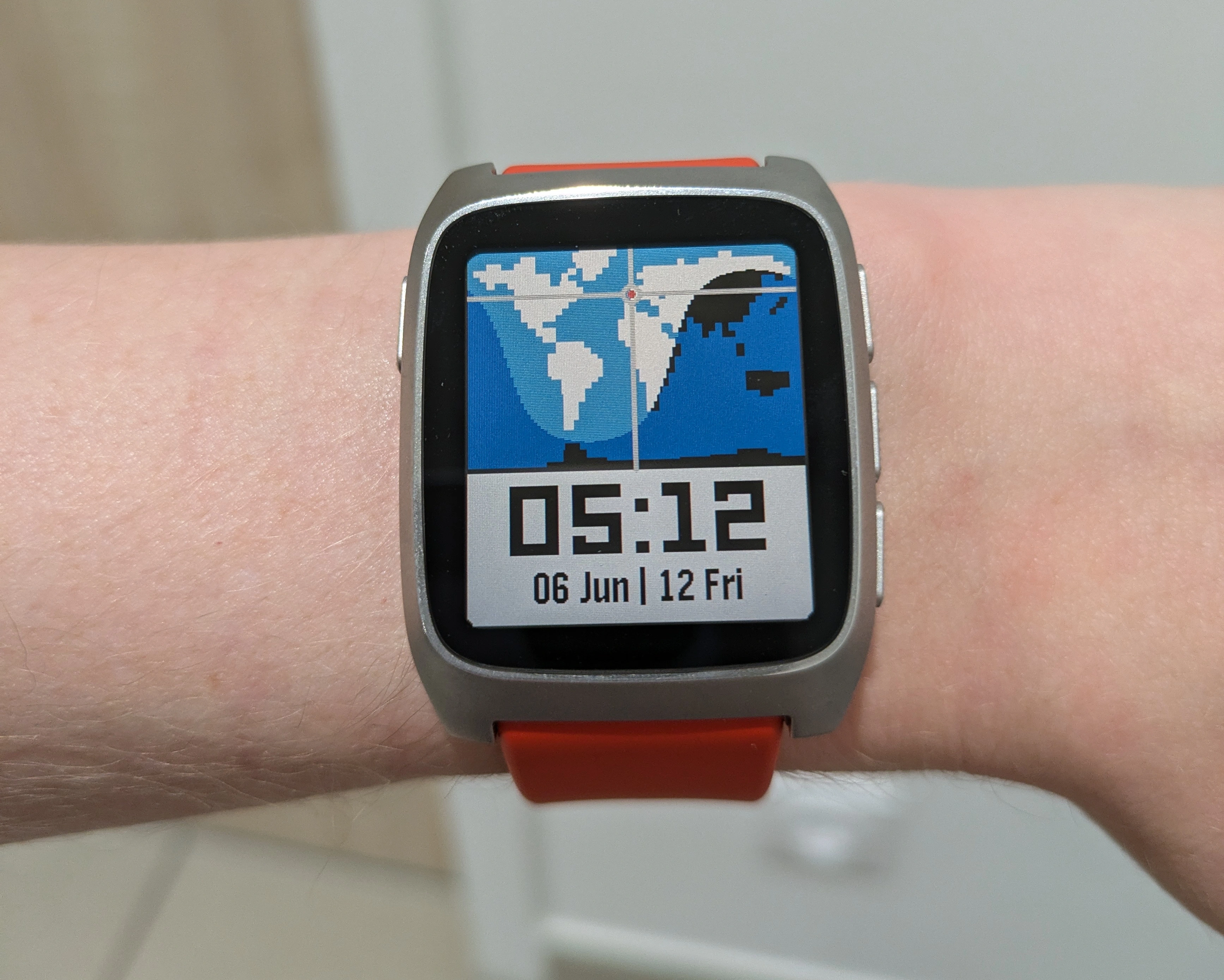 Montre pebble au poignet, un planisphère comme cadran